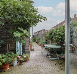 A garden with wooden decking and potted plants at The Artist's Cabin By The Sea Herne Bay