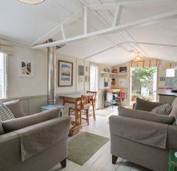 A living room with a sofa, table and chairs at The Artist's Cabin By The Sea in Herne Bay