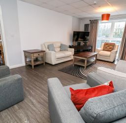 A living room with armchairs a sofa a coffee table a side table and a television at Cadwaladr in Bontnewydd near Caernarfon