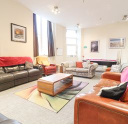 A large living room with multiple sofas and an armchair around a wooden coffee table and a pool table in the background at The Lombard in Dolgellau