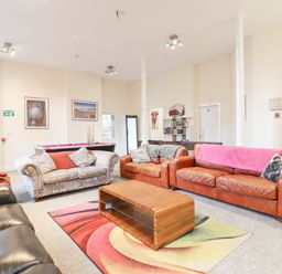 A living room with sofas a wooden coffee table a colorful rug and a pool table at The Lombard in Dolgellau