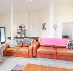 A living room with two brown leather sofas a pool table and a bookshelf at The Lombard in Dolgellau