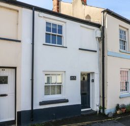 Exterior of a row of terraced houses with numbered doors and windows on a street at Peppers Cottage in Appledore
