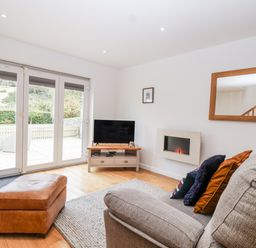 A living room with a sofa and television at Mariners Rest in Gorran Haven
