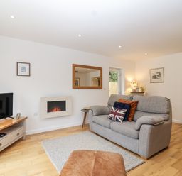 A living room with a sofa and TV at Mariners Rest in Gorran Haven