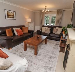 A living room with two brown leather sofas a beige sofa and a wooden coffee table at Sparrow House in Alnwick