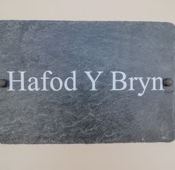 A slate sign with the text Hafod Y Bryn at Hafod Y Bryn Harlech