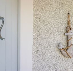 A door handle and a decorative anchor on a wall at Hafod Y Bryn Harlech