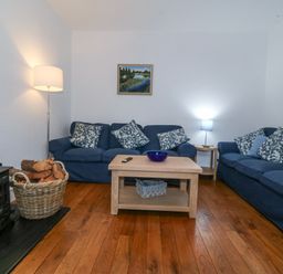 A living room with a sofa and a coffee table at Ty Capel Bethania in Nant Gwynant