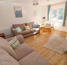 A living room with a sofa and dining area at No.22 The Clicketts in Tenby