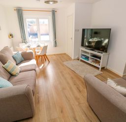 A living room with a sofa and dining table at No.22 The Clicketts Tenby