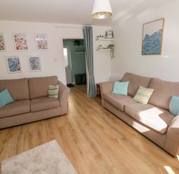 A living room with two sofas and wall art at No.22 The Clicketts in Tenby