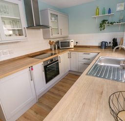 A kitchen with cabinets and appliances at No.22 The Clicketts in Tenby