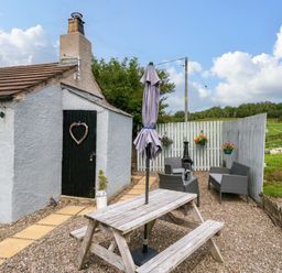 An outdoor area with a table and chairs at High Wreah Bolt Hole in Cleator Moor