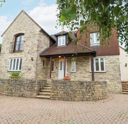 The exterior of a stone house with multiple windows and a tiled roof at Sunningdale Rise in Preston