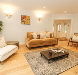 A living room with sofas armchair coffee table rug and a plant at Sunningdale Rise in Preston