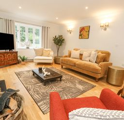 A living room with sofas coffee table and television at Sunningdale Rise in Preston