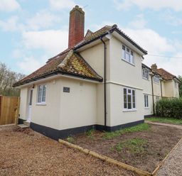 A cream colored house with a tiled roof a gravel driveway and a garden at 3 Chantry Cottages Campsea Ashe near Woodbridge
