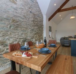 A dining room with a wooden table and chairs at Beudy