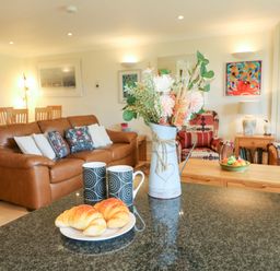A living room with a sofa and coffee table at 5 Thurlestone Beach in Thurlestone