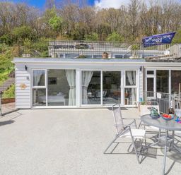 An outdoor dining area with a table and chairs at Shells Cottage in Looe