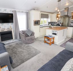 A living room with a sofa and armchair at A and C Lodge-Plot 21 Armathwaite