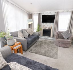 A living room with a sofa and armchair at A and C Lodge-Plot 21 Armathwaite