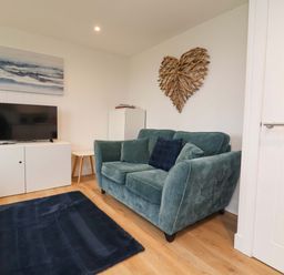 A living room with a sofa and television at Cassia in Kilkhampton
