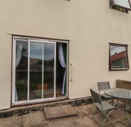 An outdoor area with a sliding door and seating at Flodden Apartment in Wooler