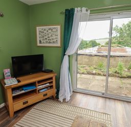 A living room with a television and a sofa at Flodden Apartment in Wooler