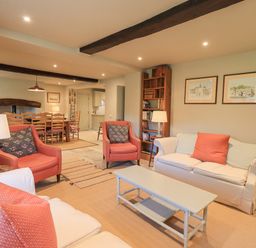 A living room with armchairs a sofa a coffee table a bookshelf and a dining table at Green Yew in Winster near Bowness-On-Windermere