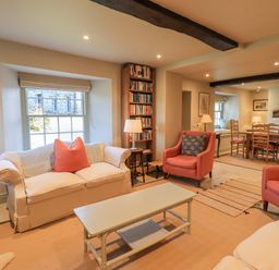 A living room with sofas chairs coffee table bookshelf and dining table at Green Yew in Winster near Bowness-On-Windermere
