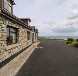 An outdoor area with a stone wall and driveway at Doonalton House, Dromore West, County Sligo