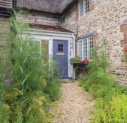 An exterior view with a front door and garden at The Elbow in Frampton