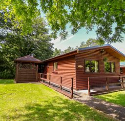 A cabin with a porch and garage at The Red in Llanerch Park near St Asaph