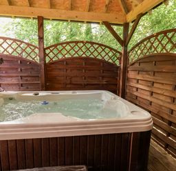 A hot tub enclosed by wooden panels at The Red in Llanerch Park near St Asaph