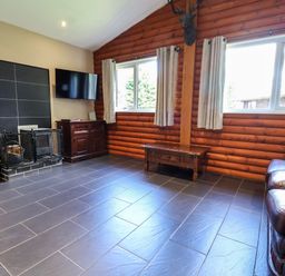 A living room with a television and fireplace at The Red in Llanerch Park near St Asaph