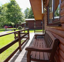 An outdoor area with a wooden bench and pathway at The Roe in Llanerch Park near St Asaph