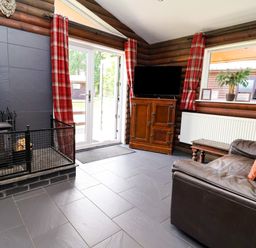 A living room with a sofa and television at The Roe in Llanerch Park near St Asaph