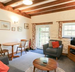 A living room with a table and chairs at Royal Oak Farm Cottage Betws-y-Coed