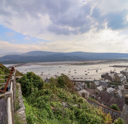 A view of a coastal town with boats on water and hills in the background at Pengarreg in Barmouth