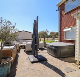 An outdoor space with a hot tub and seating area at The Farmhouse in St. Osyth