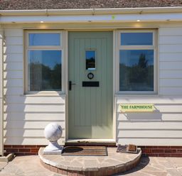 An entrance with a green door and sign at The Farmhouse in St. Osyth