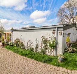 An exterior view of a building with plants and pathways at Burlodge Swimbridge near Barnstaple