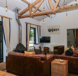A living room with a television and fireplace at Burrows in Venn Ottery near Sidmouth