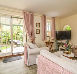 A living room with a sofa and a television at Sunset Cottage Swimbridge near Barnstaple
