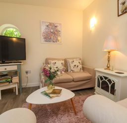 A living room with a sofa and television at Sunset Cottage in Swimbridge near Barnstaple