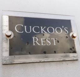 A sign with the text Cuckoo's Rest mounted on a white wall at Cuckoo's Rest in Penryn