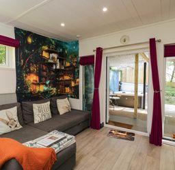 A living room with a sofa and wall mural at Squirrels Lodge in South Molton