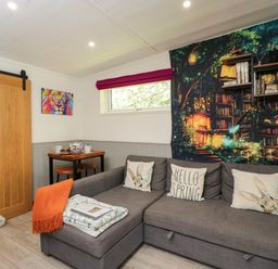 A snug with a sofa and wall art at Squirrels Lodge in South Molton